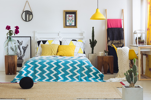 Trendy geometric decor in bright colorful bedroom with vivid colors