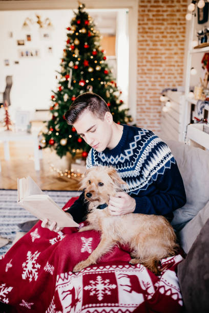 istock Young man reading a book while his dog sits nearby. 834445122