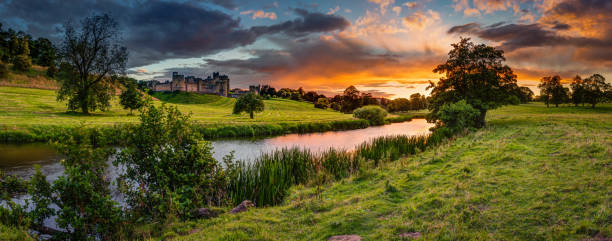 Panoramic Sunset over River Aln The River Aln runs through Northumberland from Alnham to Alnmouth. Seen here in panorama below Alnwick Town and Castle on the skyline, as the sunsets northumberland stock pictures, royalty-free photos & images