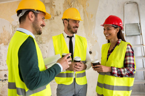 istock Group of architects talking on coffee break at construction site 834453192