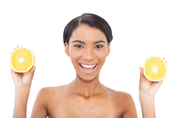 istock Cheerful attractive model holding slices of orange in both hands 834460410