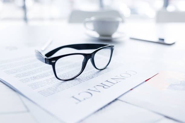 istock composition with eyeglasses and business contract on white desk 834460990
