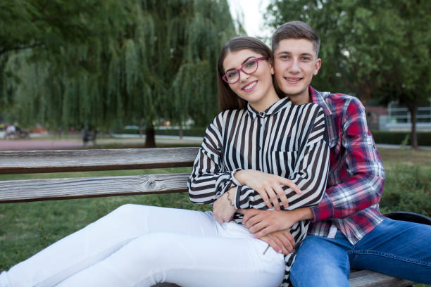 istock Loving young couple sitting in a park 834463430
