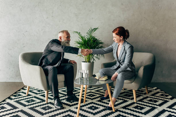 istock stylish mature business partners shaking hands in loft interior 834519034