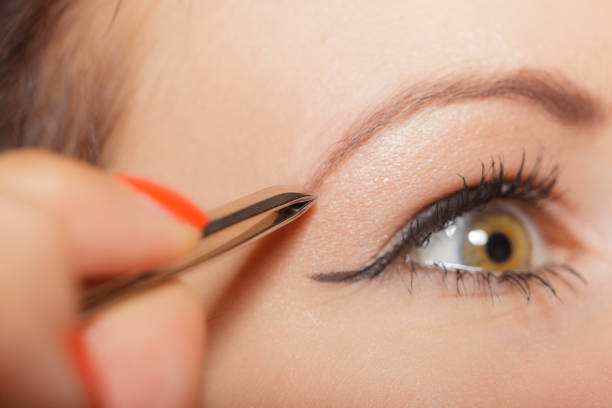 istock Girl tweezing eyebrows closeup 834519242