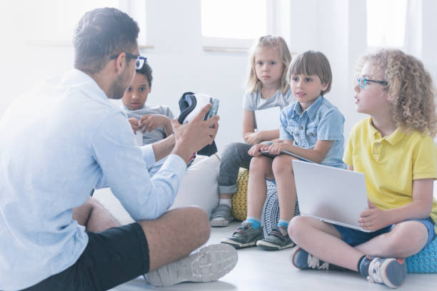 istock Happy teacher shows children the robot 834557820