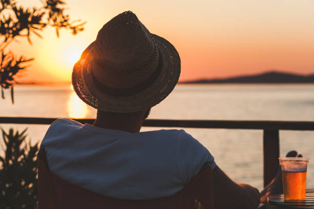 istock Young man enjoying sunset at a beach bar 834564910
