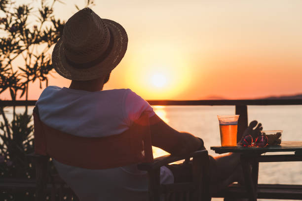 istock Young man enjoying sunset at a beach bar 834564926