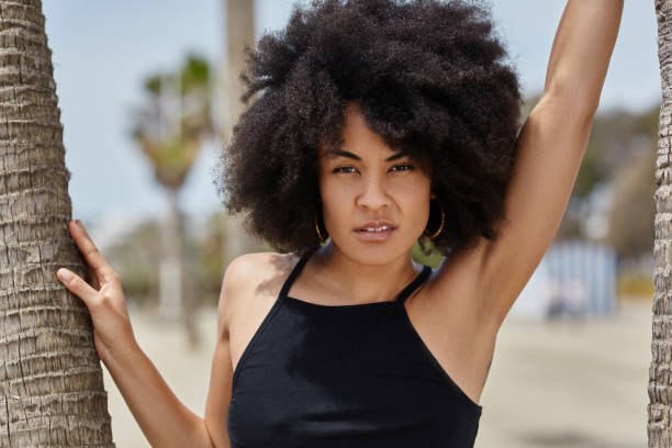 istock Young beautiful afro american woman between palms 834575512