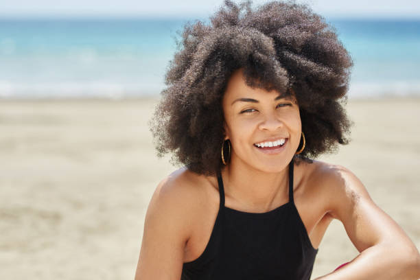 istock Young pretty afro american woman on beach smiling 834580050