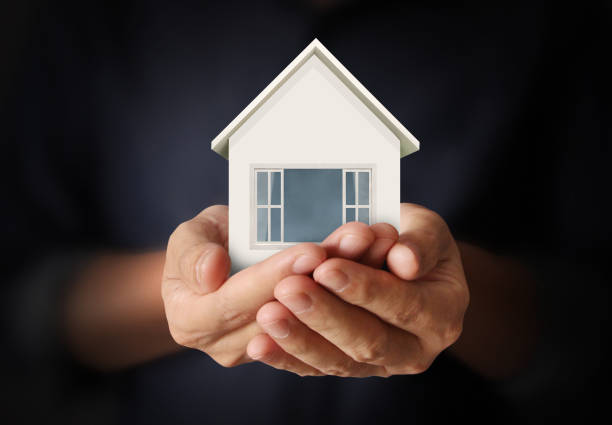 istock Mortgage concept by house from  hand 834589368