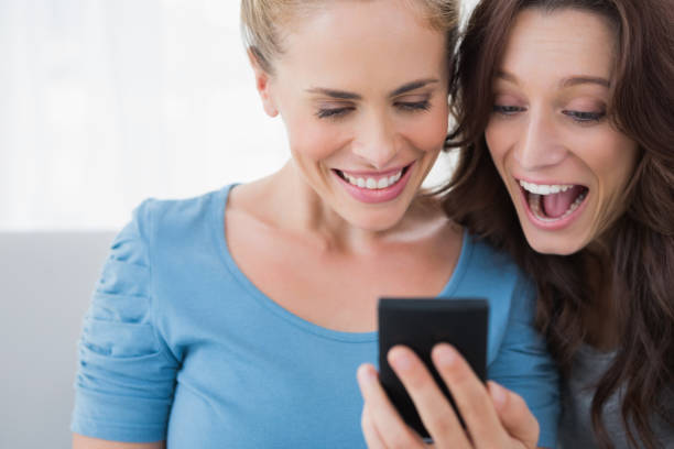 istock Cheerful friends reading message on their phone 834589656