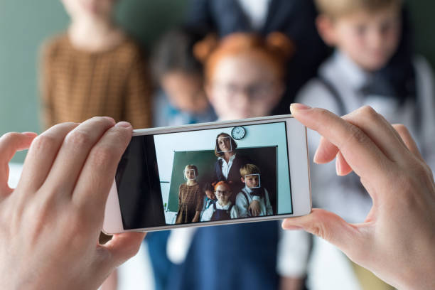 close-up view of young female teacher and cute little students photographing with smartphone close-up view of young female teacher and cute little students photographing with smartphone moving activity photos stock pictures, royalty-free photos & images