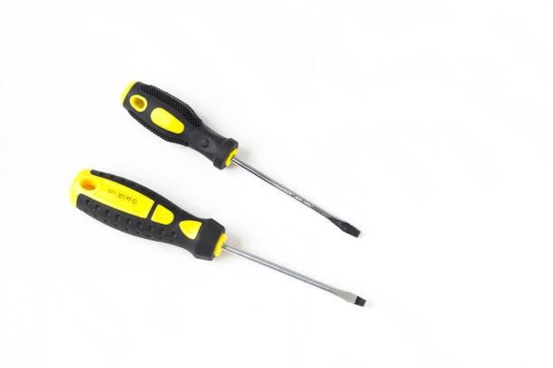 flat head screwdriver with plastic yellow and black handle - level construction isolated on white nobody imagens e fotografias de stock