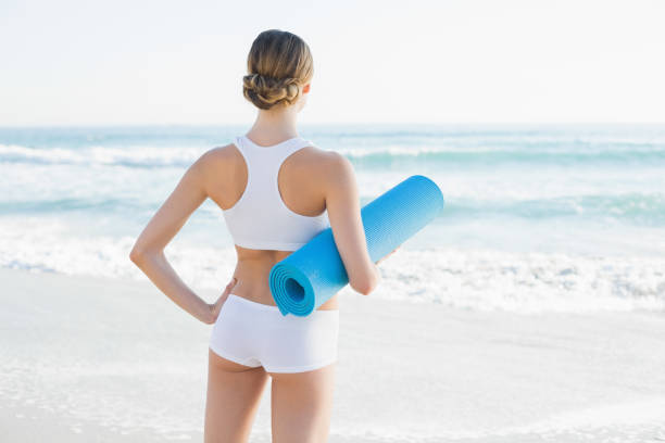 istock Slender woman holding rolled up exercise mat 834617948