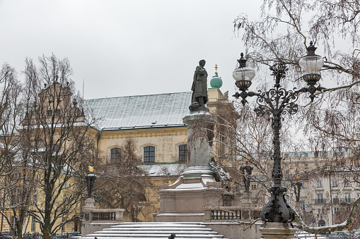 Monument of great poet Adam Mickiewicz and Carmelite church at famous Krakowskie Przedmiescie street in winter. Warsaw is the capital and largest city of Poland.