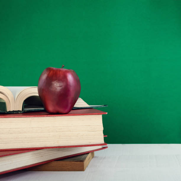 istock Books Pencil and apple on a white wooden table 834663246