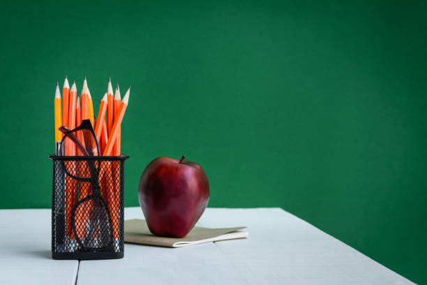 istock Books Pencil and apple on a white wooden table 834665180