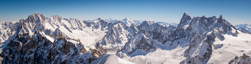 A panorama from the summit of Aiguille du Midi in the French alps looking over the snow capped peaks and vast glaciers