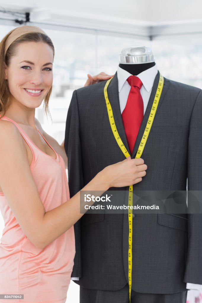 Female fashion designer measuring suit on dummy Portrait of a female fashion designer measuring suit on dummy at office 30-34 Years Stock Photo