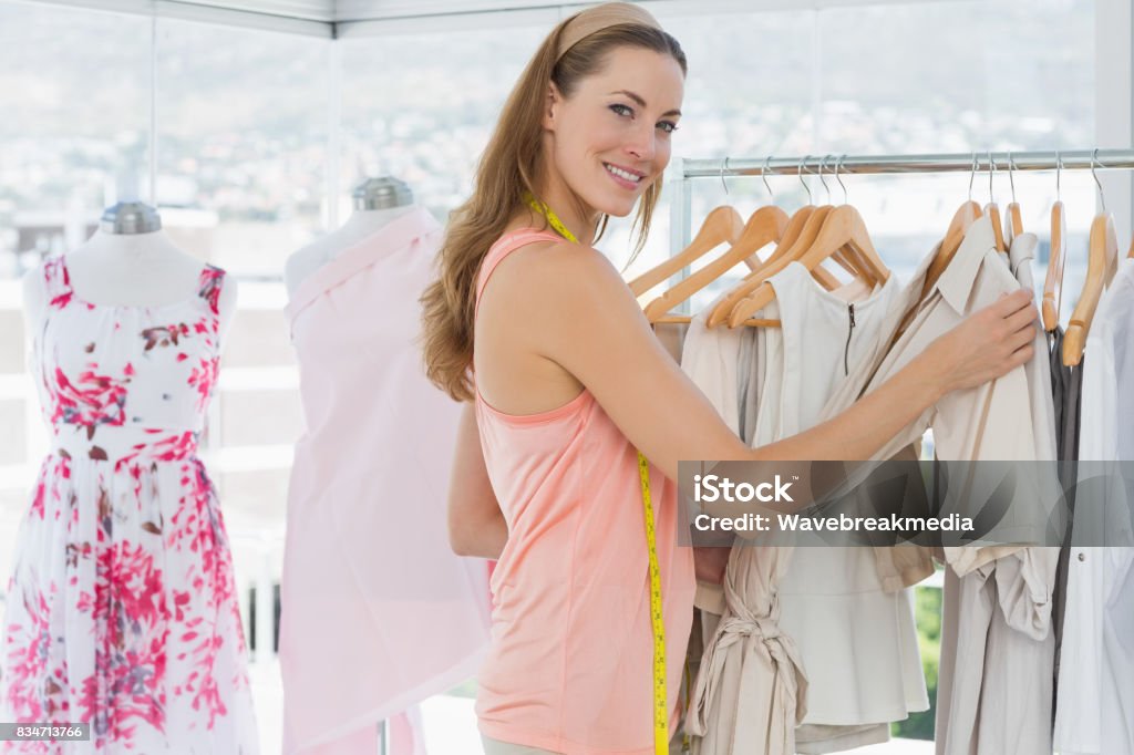 Beautiful female fashion designer with rack of clothes Portrait of a beautiful female fashion designer with rack of clothes in the store 30-34 Years Stock Photo