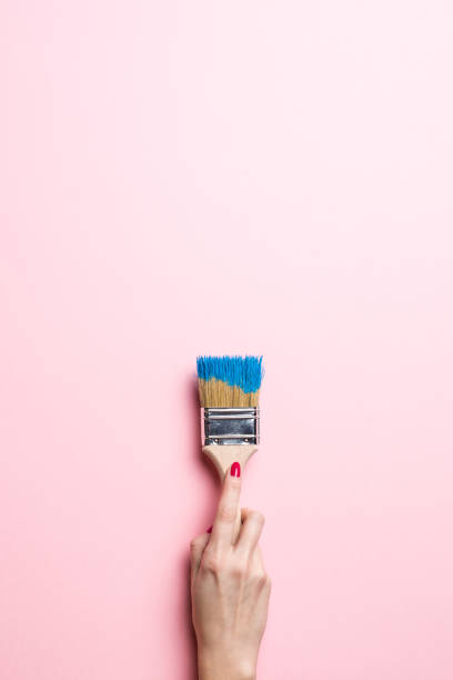 istock Woman painting empty pink wall 834714168