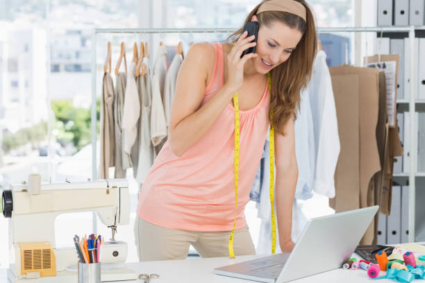 istock Fashion designer using laptop and cellphone in studio 834714362
