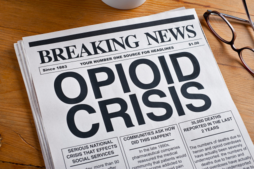 Opioid Crisis Newspaper Headline. Newspaper is on a Desk