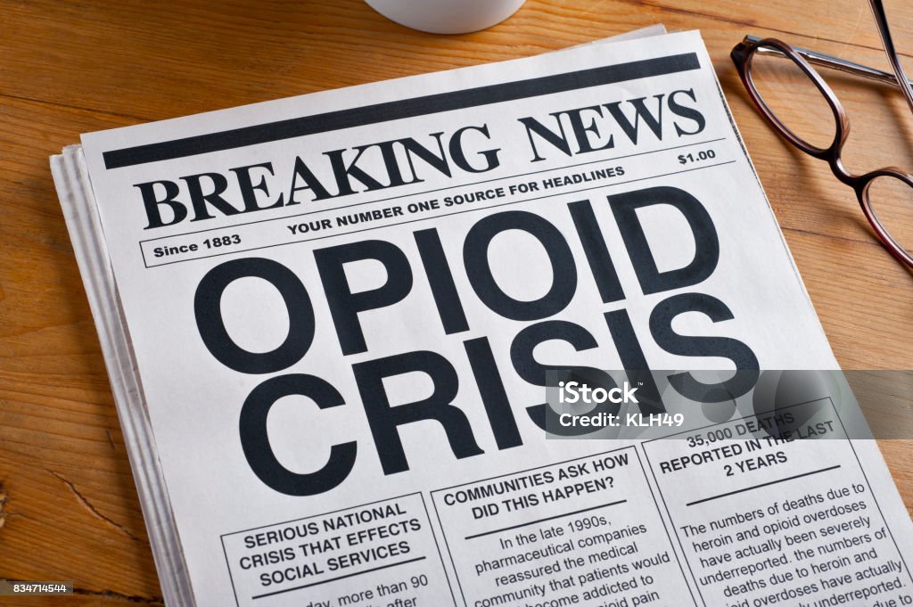 Opioid Crisis Newspaper Headline. Newspaper is on a Desk Opioid Stock Photo