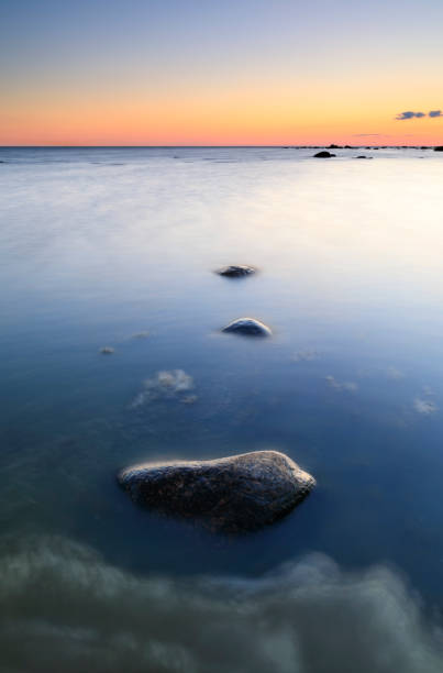 istock Several rocks in quiet sea at sunset 834716750