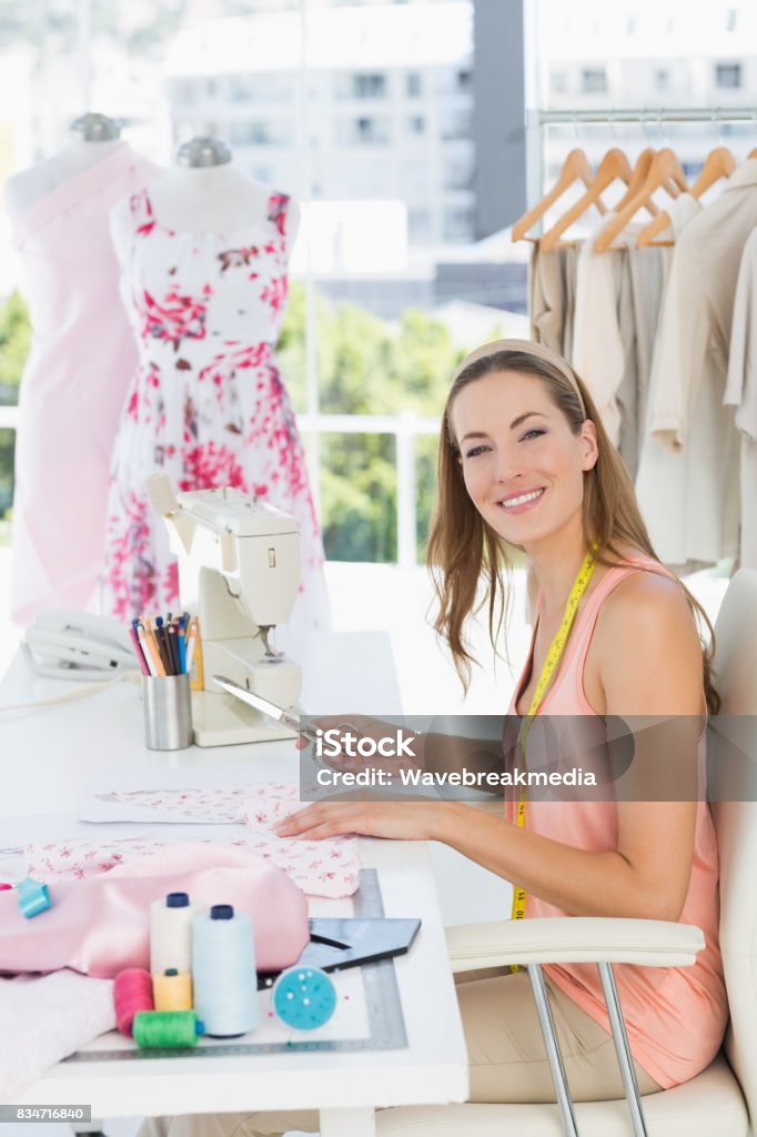Portrait of a female fashion designer working on fabrics Side view portrait of a young female fashion designer working on fabrics in the studio 30-34 Years Stock Photo