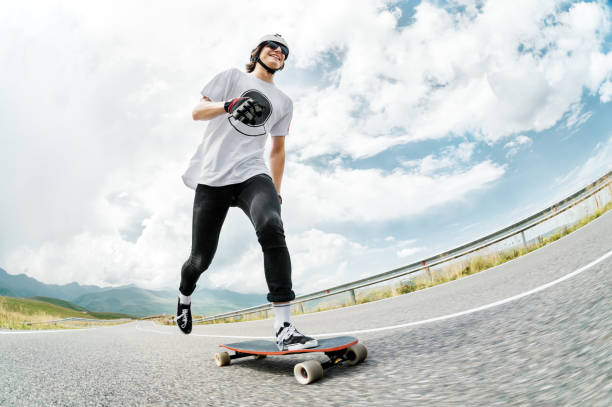 istock A guy in a helmet and sunglasses accelerates pushing his foot on his longboard 834722738