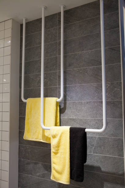 istock Yellow and Black towels hanging on plastic bar Bathroom accessory 834727232