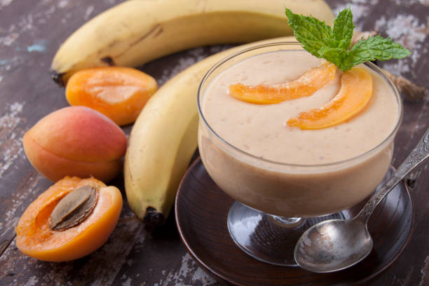 istock Smoothies with apricot and banana in a vase on an old wooden table 834732816