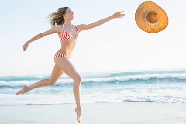 istock Elegant young woman jumping on beach 834735824