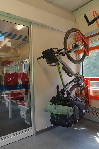 Mountain bike with saddlebags  is transported in public transportation, inside in the train.