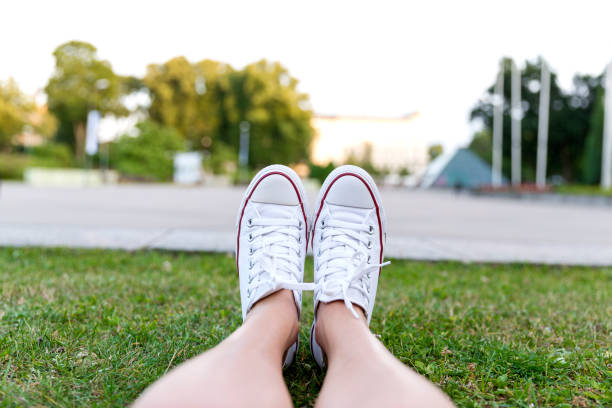 Sneakers on green grass in city park