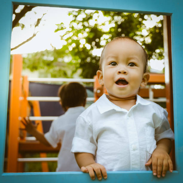 Asian boy playing in the playground - fotografia de stock