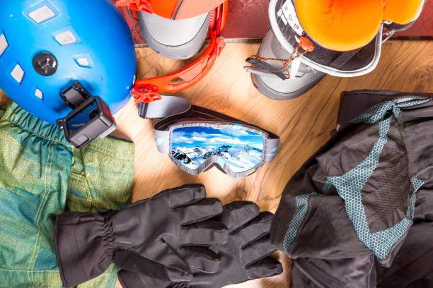 getting ready for winter vacation. set of snowboard equipment on the wooden floor. goggles, snowboard, jacket, boots, gloves, suitcase - snowboard boot imagens e fotografias de stock