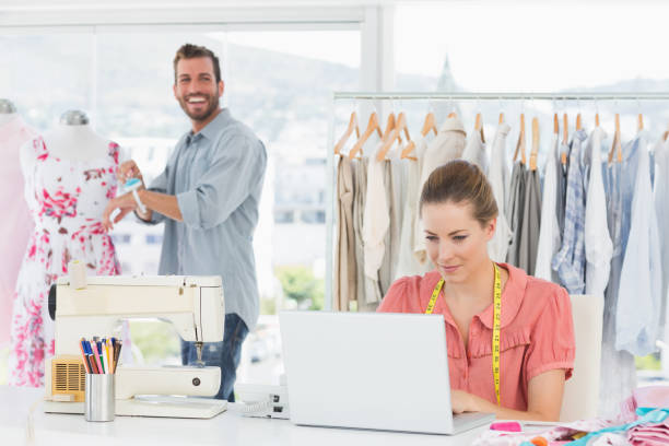 istock Woman using laptop with fashion designer working at studio 834759310