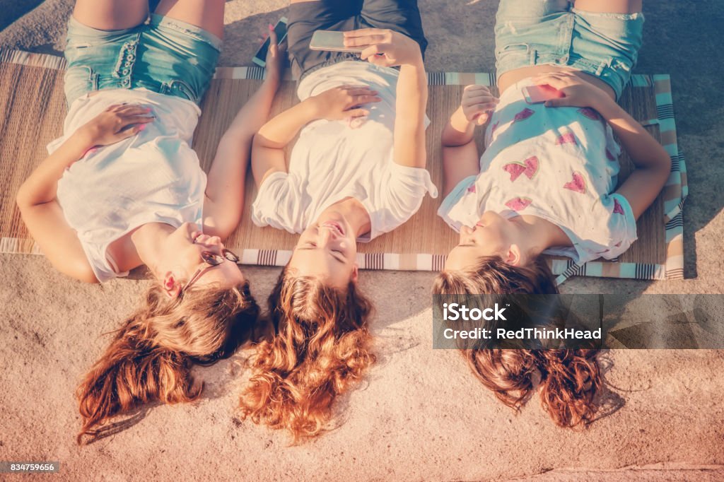 Teenage girls chilling out at the beach and taking a Selfie Summer holidays / Teenage concept Adolescence Stock Photo