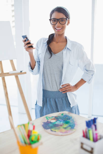 istock Cheerful pretty artist text messaging 834761638