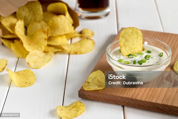 Foto de Batatas Fritas Em Molho De Saco E Mergulhando Um Papel Em Uma Mesa De Madeira e mais fotos de stock de Batata Frita de Pacote