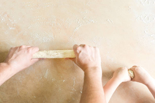 Children's and dad's hands makes raw dough