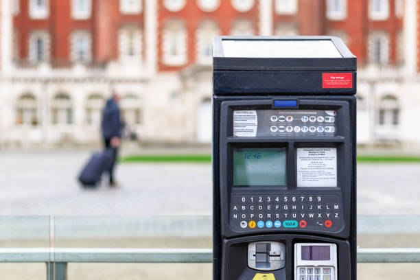Car park ticket machine on a London street with an unidentified traveller Car park ticket machine on a London street with an unidentified traveller in the background parking meter stock pictures, royalty-free photos & images