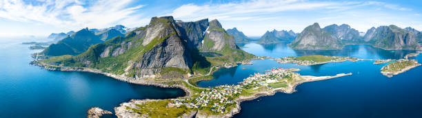Aerial panoramic view of Reine, Lofoten, Norway, sunny arctic summer Aerial panoramic view of Reine traditional fishing village in the Lofoten archipelago in northen Norway with blue sea and mountains during sunny arctic summer reine lofoten stock pictures, royalty-free photos & images