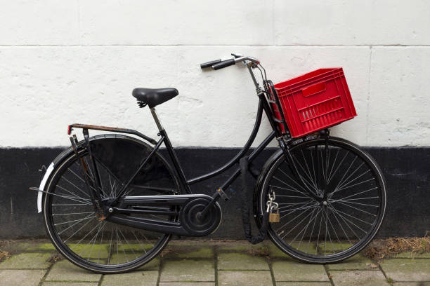 istock Black bicycle with red basket at white wall 834775934