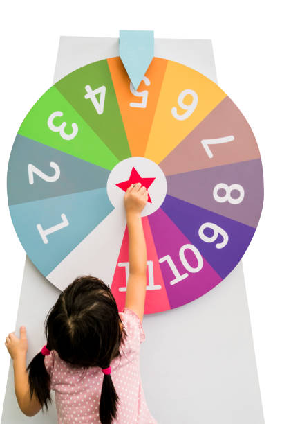 Asian girl trying to spin the huge colorful fortune wheel stock photo