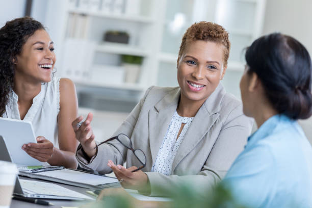 istock Three coworkers laugh together during meeting 834795366