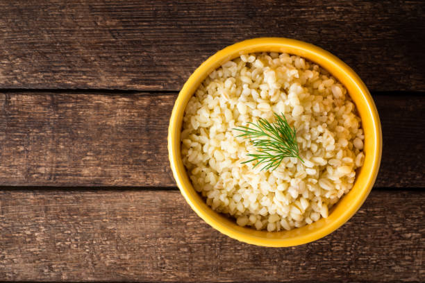 istock Bulgur with dill in yellow ceramic bowl on dark wooden background 834797454